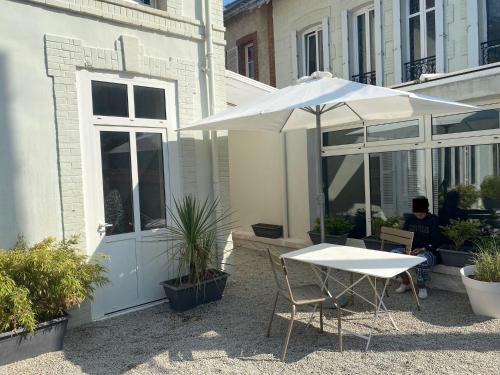 a table with an umbrella next to a building at La Côte in Granville