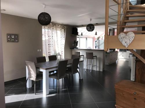 une salle à manger et une cuisine avec une table et des chaises dans l'établissement Villa contemporaine à 2 kms de Chartres, à Gellainville