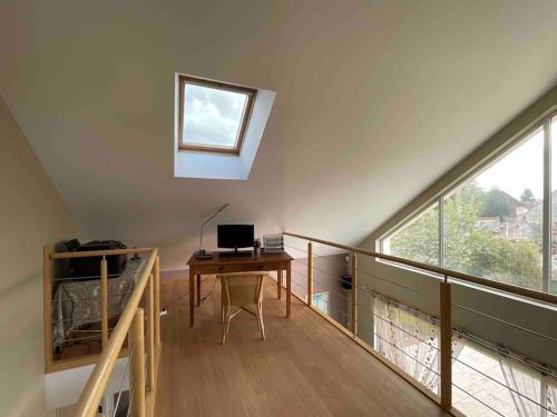 Zimmer im Dachgeschoss mit einem Schreibtisch und einem Fenster in der Unterkunft Villa contemporaine à 2 kms de Chartres 