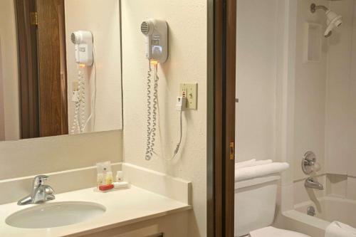 a bathroom with a sink and a phone on the wall at Ramada by Wyndham Sterling in Sterling