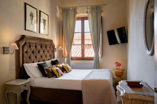 a bedroom with a large bed and a window at Mabelle Firenze Residenza Sassetti in Florence