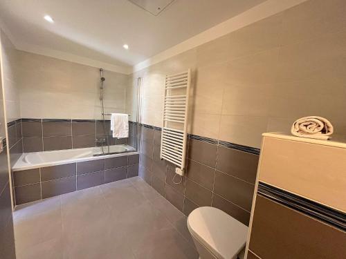 a bathroom with a tub and a toilet and a sink at Appartement Fréjus, 3 pièces, 4 personnes - FR-1-226A-290 in Fréjus