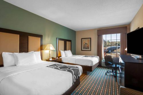 a hotel room with two beds and a desk at La Quinta by Wyndham Stonington-Mystic Area in Pawcatuck