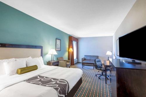 a hotel room with a bed and a flat screen tv at La Quinta by Wyndham Stonington-Mystic Area in Pawcatuck