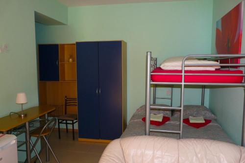 a room with two bunk beds and a desk at Why Me Eco-friendly Rooms in Tbilisi City