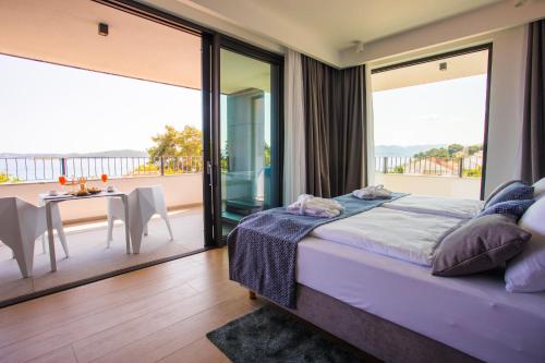 1 Schlafzimmer mit einem Bett und einem Balkon mit einem Tisch in der Unterkunft Hotel Crystal in Orebić