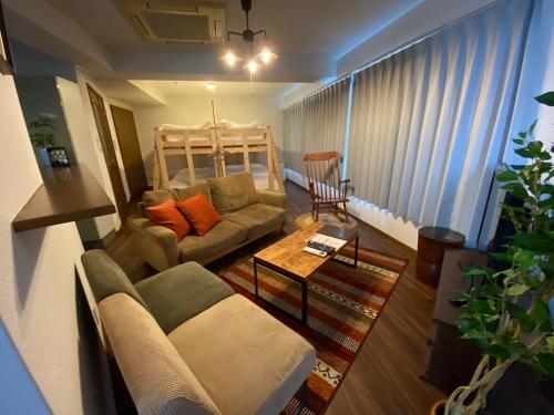 a living room with a couch and a table at AIRSTAR TENJIN パインヒル警固505 - Apartment stay in Fukuoka