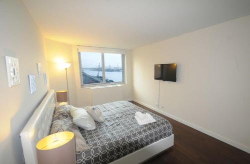 1 dormitorio con cama con almohadas y ventana en 2 BR 1.5t Bath in Midtown West, en Nueva York
