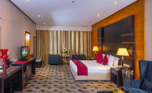 una habitación de hotel con una cama y un televisor en Diva Hotel, en Manama