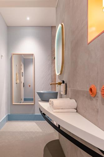 a bathroom with a sink and a mirror at Vie Via - Your Hotel in Leeuwarden