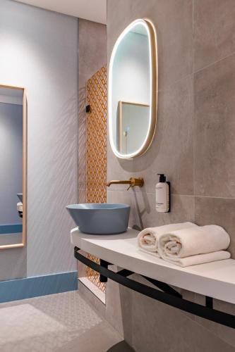 a bathroom with a sink and a mirror at Vie Via - Your Hotel in Leeuwarden