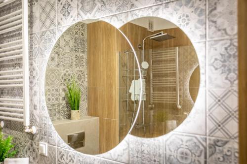 a bathroom with a shower with a round mirror at Green Park Resort A13- z dostępem do basenu, sauny, jacuzzi, siłowni in Szklarska Poręba