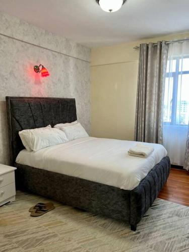 - une chambre avec un grand lit dans l'établissement Forest's Simplistic Home with a dedicated study, à Nairobi