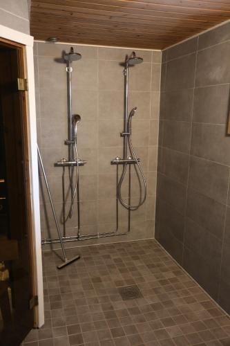 a shower in a bathroom with three shelves at Liirakka Levi in Levi