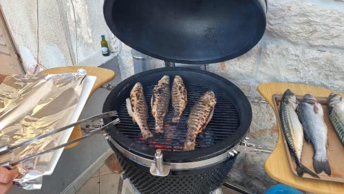 a bunch of sausages cooking on a grill at Star of stone in Jelsa