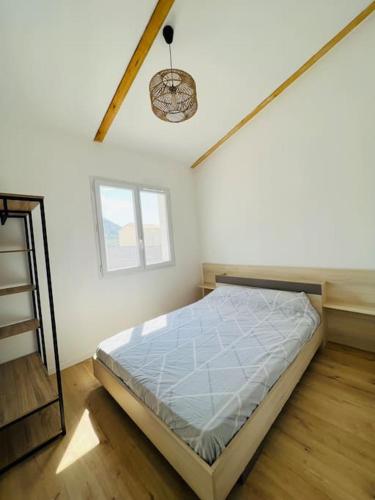 une chambre avec un lit dans une pièce blanche dans l'établissement Belle villa neuve avec jardin et parking, à Calenzana