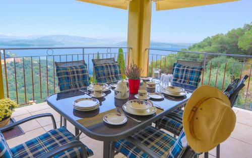 a blue table with plates and cups on a balcony at Villa Rose above Agni with amazing views in Kavalléraina