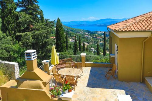a patio with a table and chairs and a view at Villa Rose above Agni with amazing views in Kavalléraina