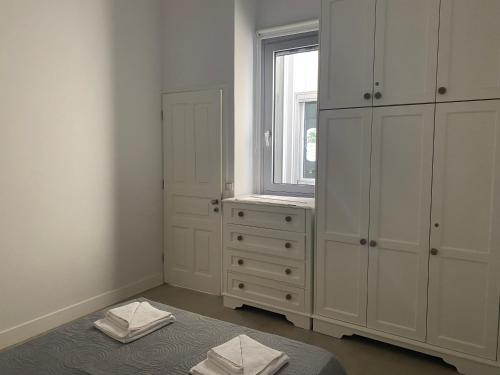 um quarto branco com uma cama e uma janela em Liz e mao em Vlachopoulátika
