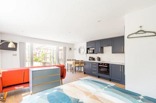 a kitchen with blue cabinets and an orange couch at Charming Chester Studio with private garden & free parking in Chester