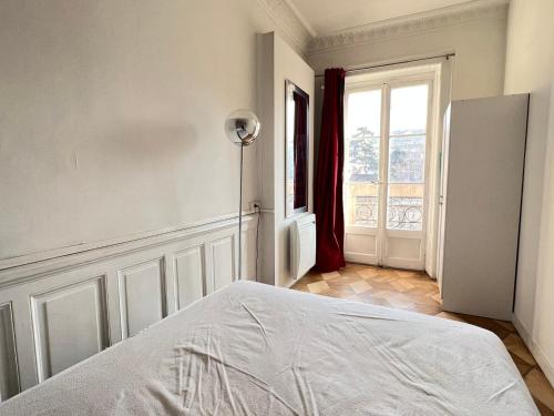 une chambre blanche avec un lit et une fenêtre dans l'établissement T1 moderne, cosy au centre-ville d'Aix-les-Bains, proche des thermes et commerces! - FR-1-555-33, à Aix-les-Bains