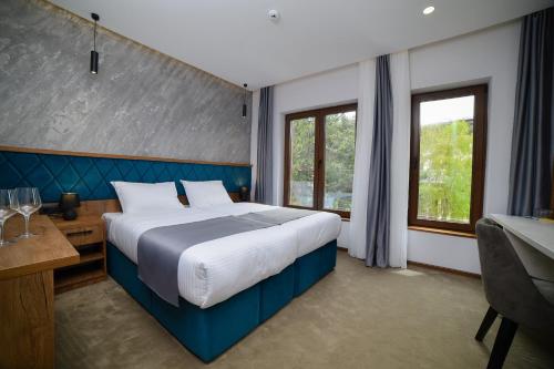 a bedroom with a large bed and a desk and window at Lakeside in Zlatibor