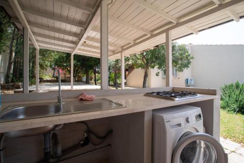 a kitchen with a sink and a washing machine at Baccu Mandara Sea View Modern Villa with Parking! in Geremeas