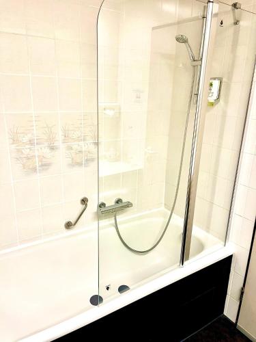 a shower with a glass door in a bathroom at Hotel Schiller in Olching