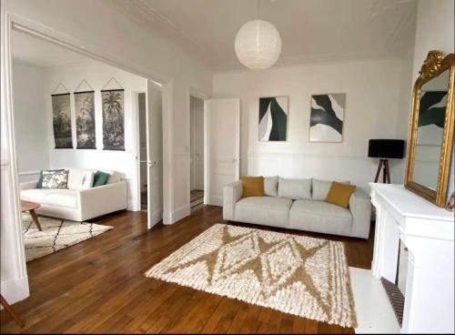 a living room with a white couch and a rug at La Côte in Granville