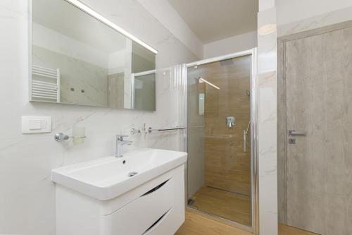 a white bathroom with a sink and a shower at Villa Dani by IstriaLux in Rovinjsko Selo