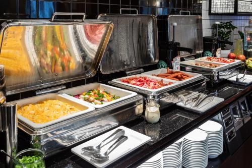 a buffet line with trays of food on at Qubus Hotel Gdańsk in Gdańsk