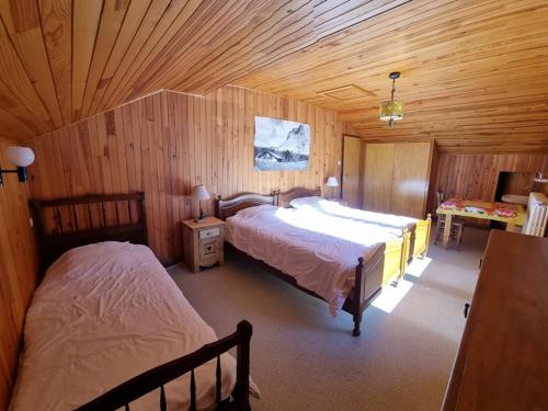 a bedroom with two beds in a wooden cabin at Grand chalet 11 pers, 4 chambres, Sud, proche ski - FR-1-733-72 in Crest-Voland
