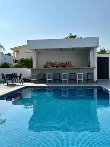 a swimming pool with a bar next to a building at Zoi Ayia Napa in Ayia Napa