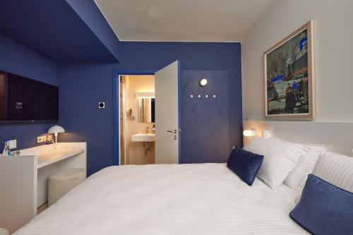 オーステンデにあるC-Hotels Burlingtonの青色のベッドルーム(白いベッド1台、シンク付)
