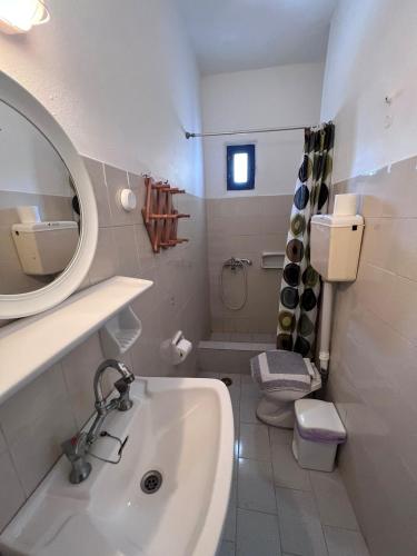 a bathroom with a sink and a toilet and a mirror at Project Town in Ios Chora