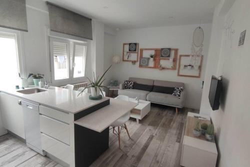 a white kitchen and living room with a couch at Apartamento Turquesa in Zaragoza