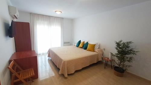 a bedroom with a bed with yellow and blue pillows at Apartment 50m from the beach by Lofties in Pineda de Mar
