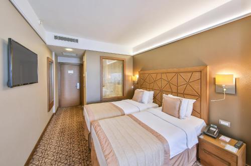 a hotel room with two beds and a flat screen tv at Ramada By Wyndham İstanbul Taksim in Istanbul