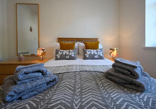 um quarto com uma cama grande e toalhas em Old Whisky Distillery Apartment em Fort William