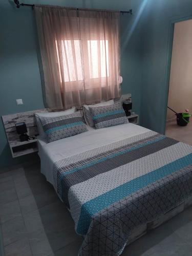 a large bed in a bedroom with a window at Akrotiri Luxury Suites in Trápeza