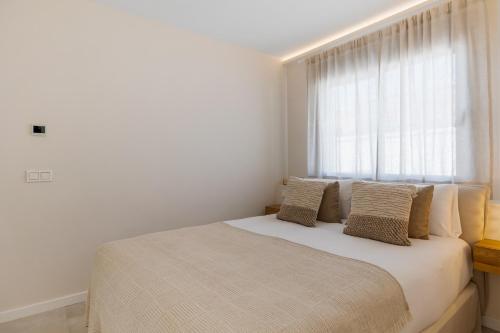 a bedroom with a large bed with a window at Casa Las Palmeras in Marbella