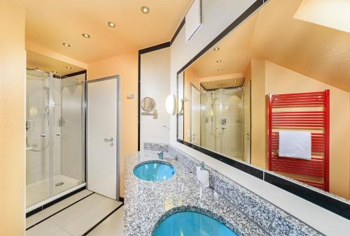 a bathroom with a large sink and a shower at Kneipp- und Wellvitalhotel Edelweiss in Bad Wörishofen