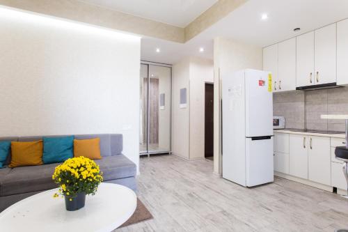 a living room with a couch and a white refrigerator at Naykova district Apartments in Kharkiv