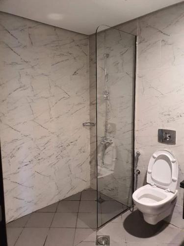 a bathroom with a toilet and a glass shower at a chilled place in Dubai