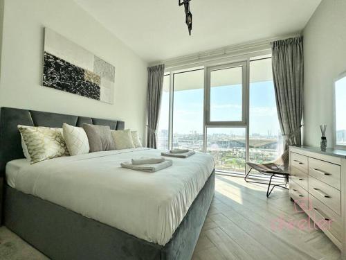 a bedroom with a large bed and a large window at Dweller - Luxury Apartment Sleep 4 in Dubai