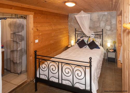 - une chambre avec un lit dans une pièce en bois dans l'établissement Oliveraie d'Olmiccia, à Olmiccia