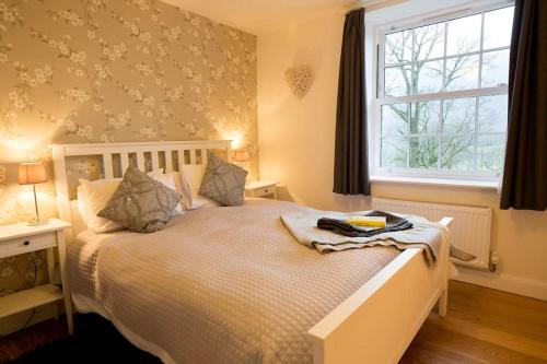 a bedroom with a white bed with a window at Langdale Cottage - 5 bedrooms and 5 bathrooms in Chapel Stile