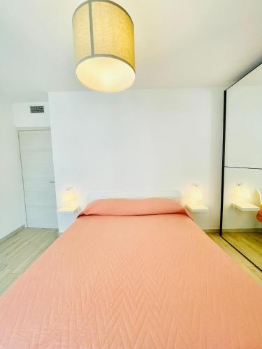 a bedroom with a bed with a pink bedspread at Emme Apartment in Cagliari