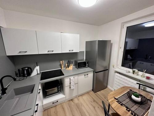 a kitchen with white cabinets and a table in it at 1 Izbovy Apartman - Širšie Centrum in Martin