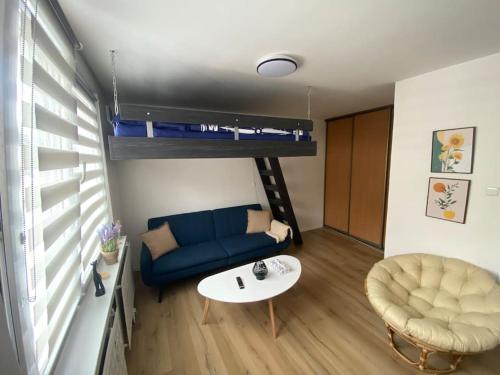 a living room with a blue couch and a table at 1 Izbovy Apartman - Širšie Centrum in Martin